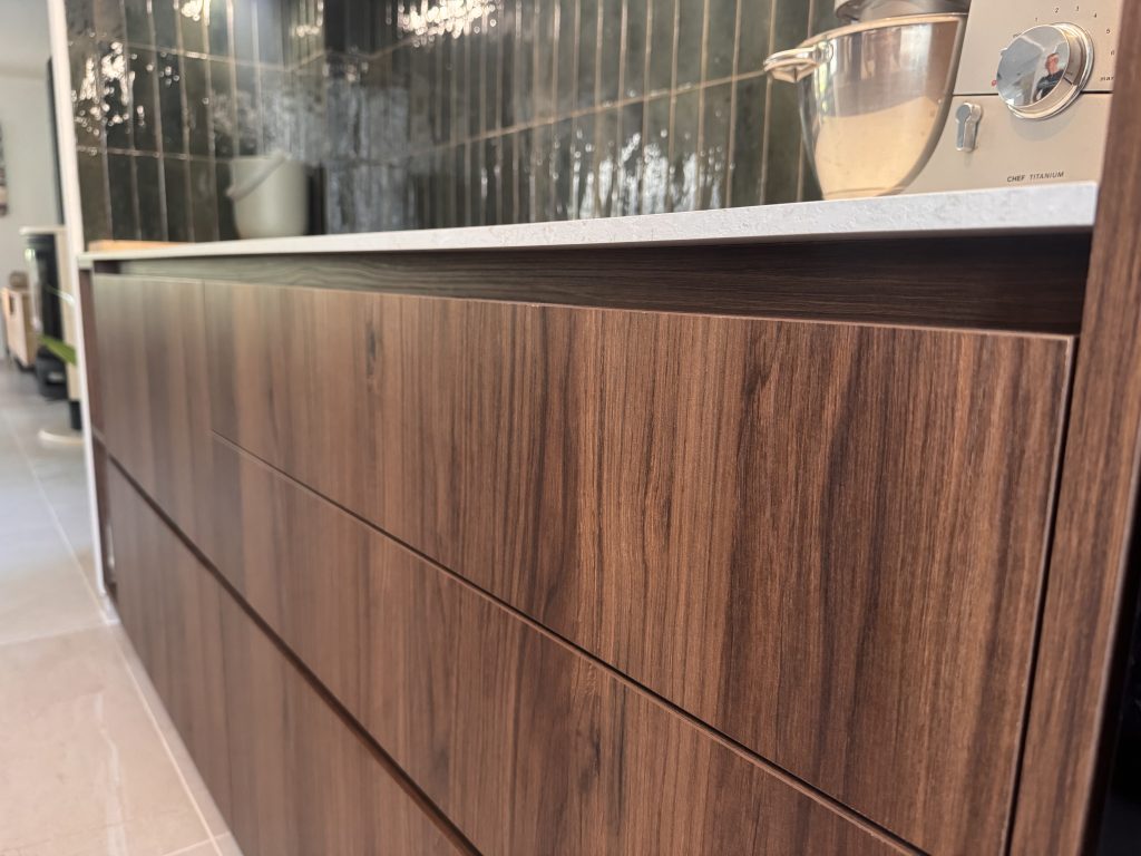 Détail des façades en bois noyer de la cuisine sur mesure