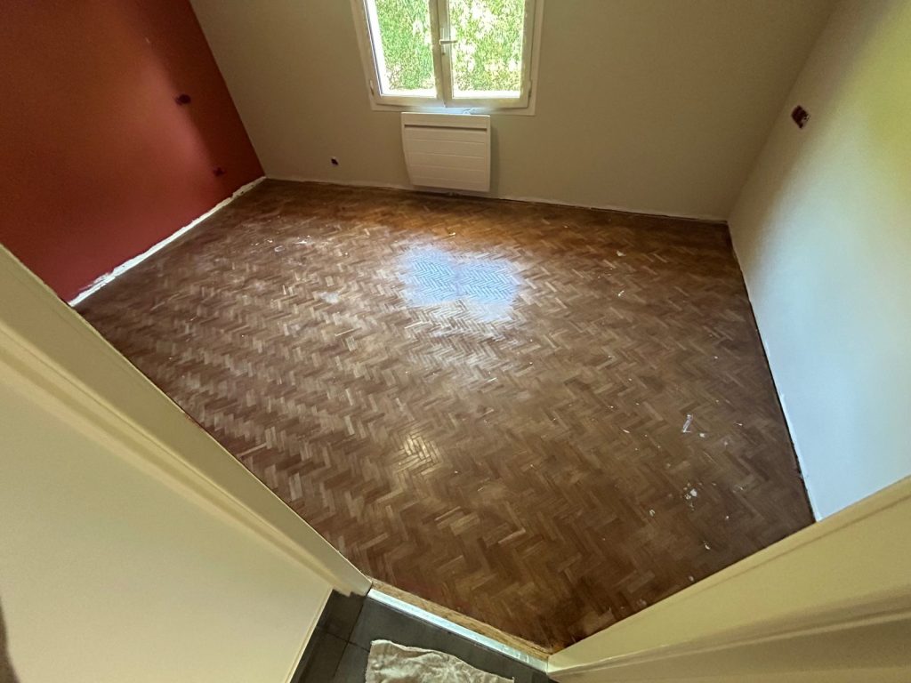 Chambre avant travaux avec ancien parquet foncé usé